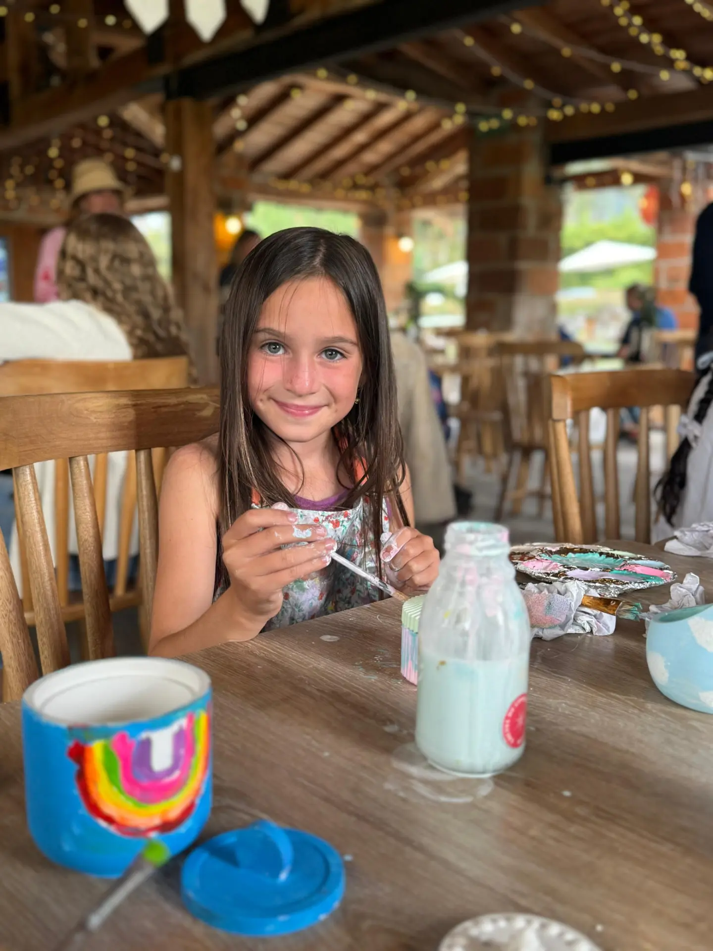 Niña pintando cerámica en la mesa