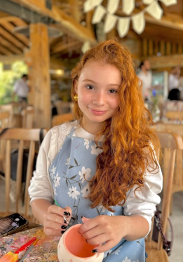 Niña pintando una pieza de cerámica